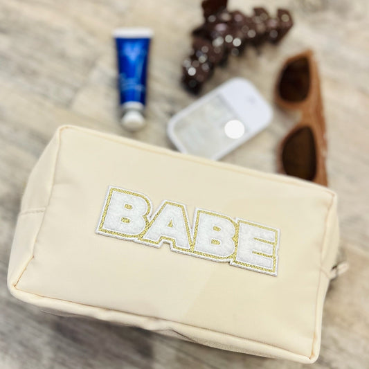 babe cosmetic bag, babe makeup bag, ivory nylon makeup pouch, travel makeup bag, cute cosmetic bag, glitter letter makeup bag, glam travel bag, toiletry pouch, nylon cosmetic case, trendy makeup organizer, babe patch letters, beauty essentials bag, gift for her, travel accessory bag, vanity storage bag, small travel pouch, stylish makeup bag, college girl gift, bridesmaid gift idea, bachelorette gift, girly travel bag, makeup lover gift, nylon toiletry bag, cute glam pouch, mini and mama matching bag