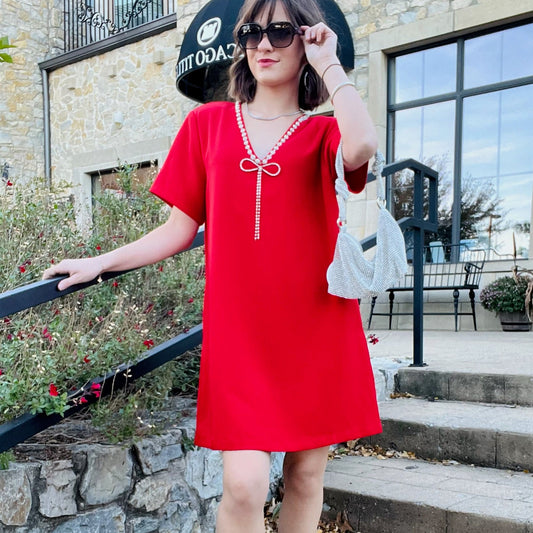 stazie dress, red mini dress, rhinestone bow dress, v neck party dress, short sleeve cocktail dress, holiday outfit, christmas party dress, red shift dress, sparkly neckline dress, statement mini dress, rhinestone trim dress, flirty red dress, boutique holiday dress, night out dress, date night outfit, festive red mini, glam party look, elegant short dress, solid red mini, special occasion outfit, chic red cocktail dress, timeless red dress, sparkly bow detail dress, classy holiday attire