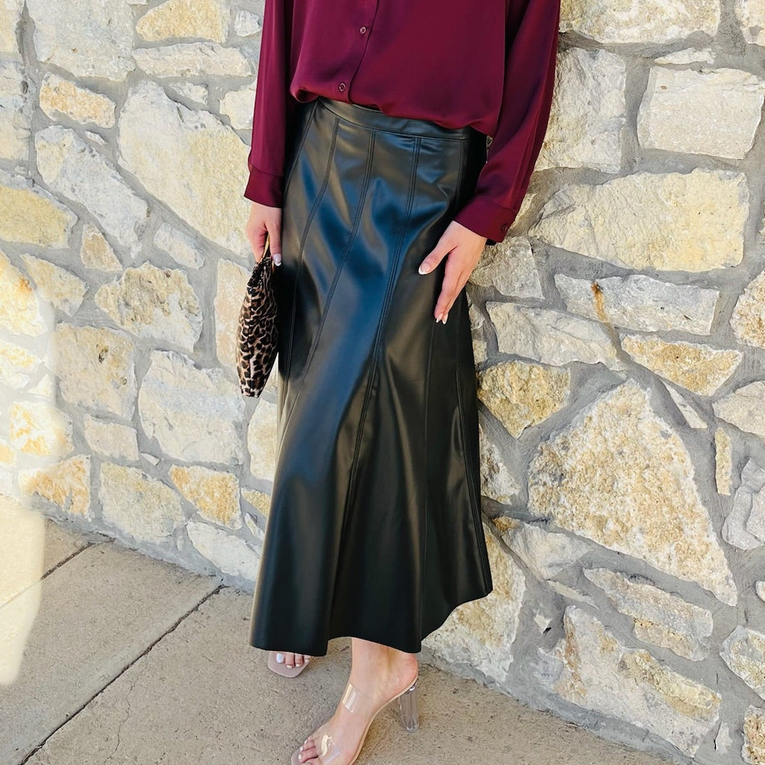 black faux leather skirt, vegan leather skirt, pleather midi skirt, flared leather skirt, black midi skirt, side zip skirt, chic black skirt, fall fashion outfit, edgy leather skirt, versatile skirt, boutique midi skirt, trendy faux leather skirt, vegan leather fashion, statement skirt, dressy black skirt, women’s midi skirt, street style outfit, fall outfit idea, night out skirt