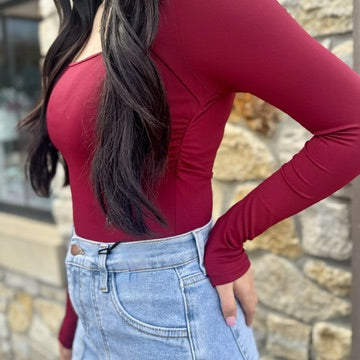 long sleeve bodysuit, square neck bodysuit, fitted bodysuit, stretchy bodysuit, nylon elastane bodysuit, versatile wardrobe essential, chic layering piece, flattering bodysuit for women, everyday basics, sleek square neckline, snap closure bodysuit, form-fitting top, dress up or down, minimalist style bodysuit, trendy neutral bodysuit