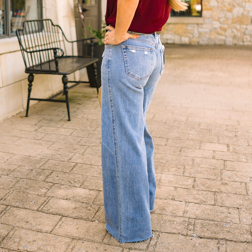 mid rise wide leg jeans, comfort stretch denim, raw hem jeans, slightly distressed jeans, full length denim, clean cut jeans, everyday wide leg jeans, modern denim style, casual chic jeans, versatile denim pants, polished wide leg denim, relaxed fit jeans, trendy wide leg silhouette, comfortable mid rise jeans, classic blue jeans, effortless everyday denim, stylish raw edge jeans, laid back denim look, timeless wide leg jeans, soft stretch denim