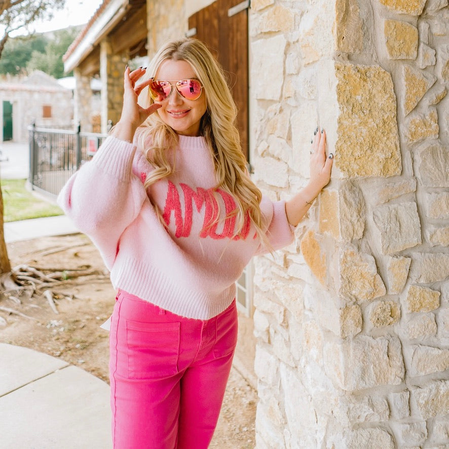 pink sweater, l’amour sweater, love sweater, graphic pullover, cozy chic sweater, valentine sweater, flirty feminine sweater, light pink sweater, pink lettering sweater, relaxed fit pullover, crew neck sweater, ribbed knit sweater, boutique sweater, soft cozy knit, girls night outfit, parisian style sweater, casual chic sweater, cozy gift idea, trendy fall sweater, cute pink sweater