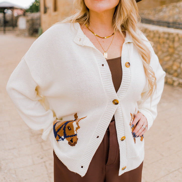 horse cardigan, western-inspired cardigan, graphic knit cardigan, ivory button-down cardigan, cozy fall cardigan, horse print sweater, boutique western fashion, long sleeve knit cardigan, casual chic cardigan, soft knit sweater, fall statement sweater, horse lover gift, rustic chic cardigan, western style sweater, ivory knit cardigan, layering cardigan, trendy fall sweater, women’s western cardigan, boutique fall fashion, unique horse print top, casual fall outfit, chic graphic sweater, autumn wardrobe stap
